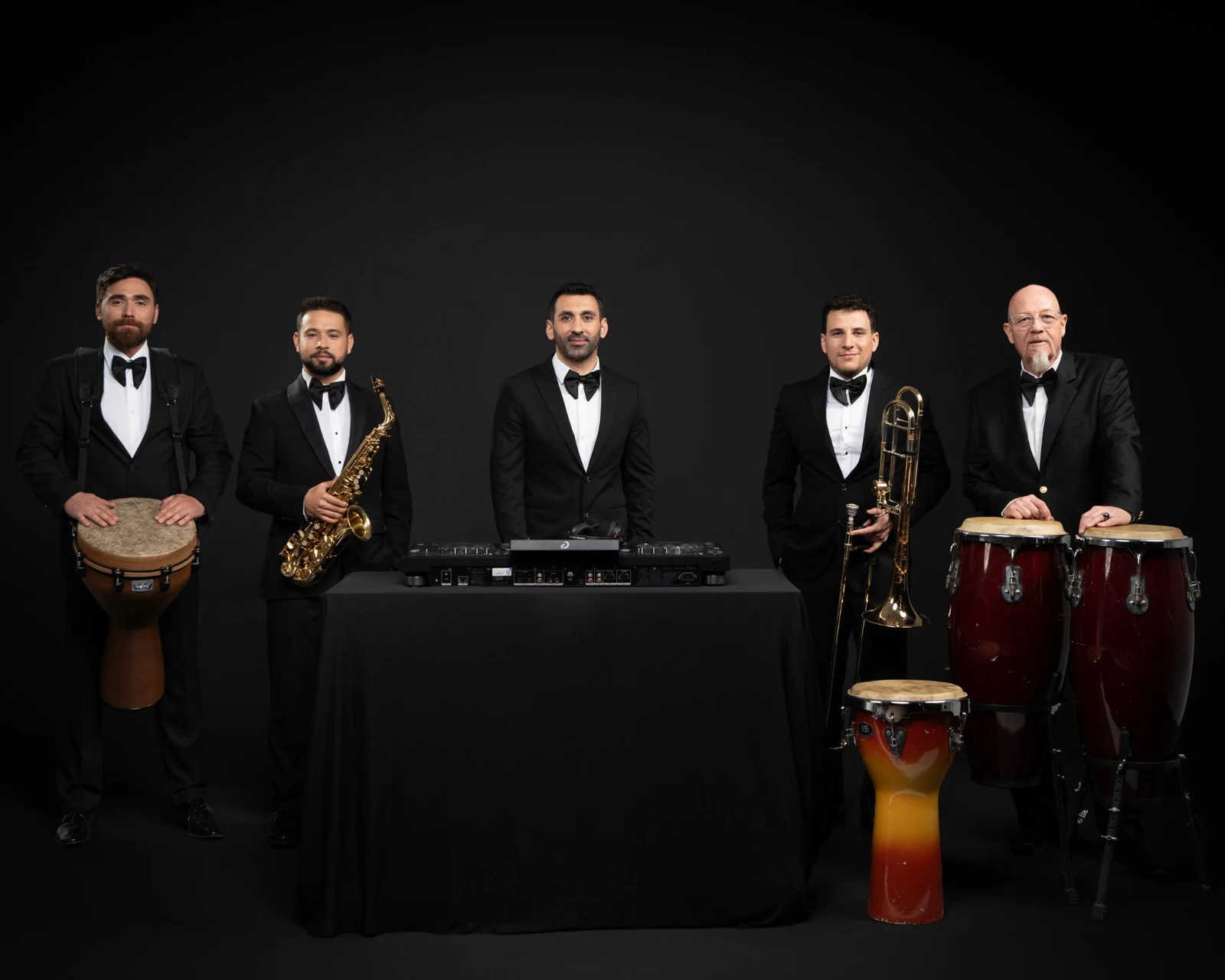 Ortada DJ, çevresinde perküsyon, saksafon, trombon ve kongalar